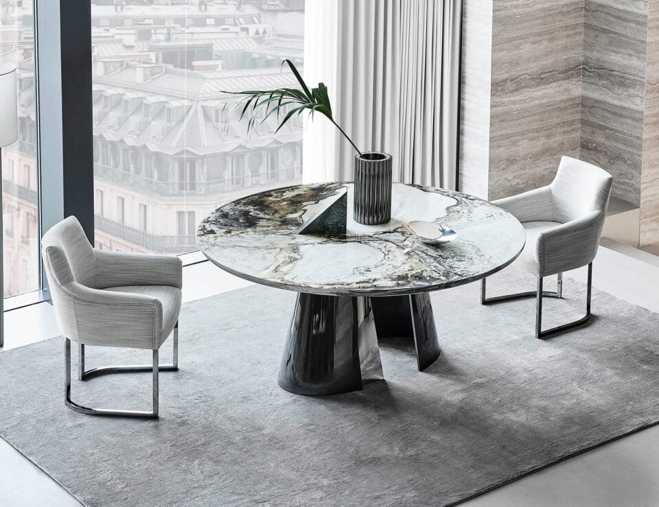 Round marble dining table with Cipollino finish and dark base in dining room setting