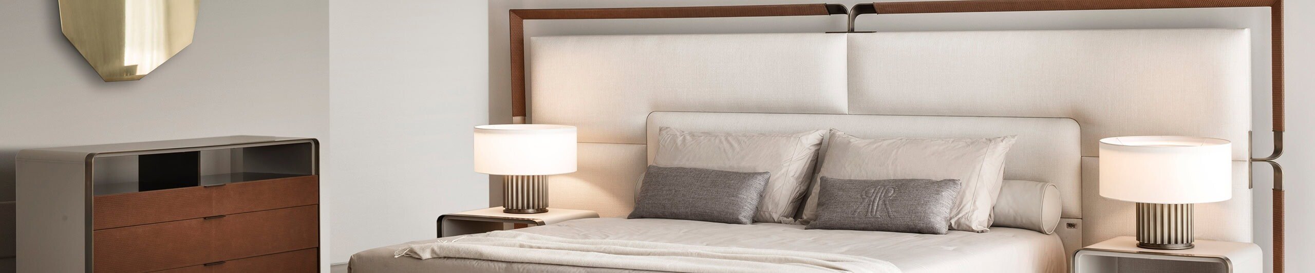 Upholstered bed with tall fabric headboard and wood frame in bedroom setting