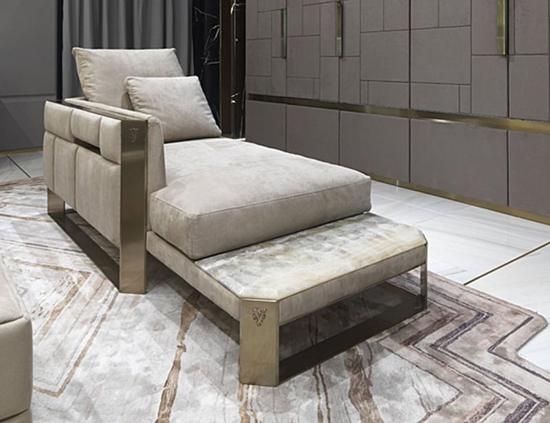 Beige upholstered chaise lounge with metal frame and marble base