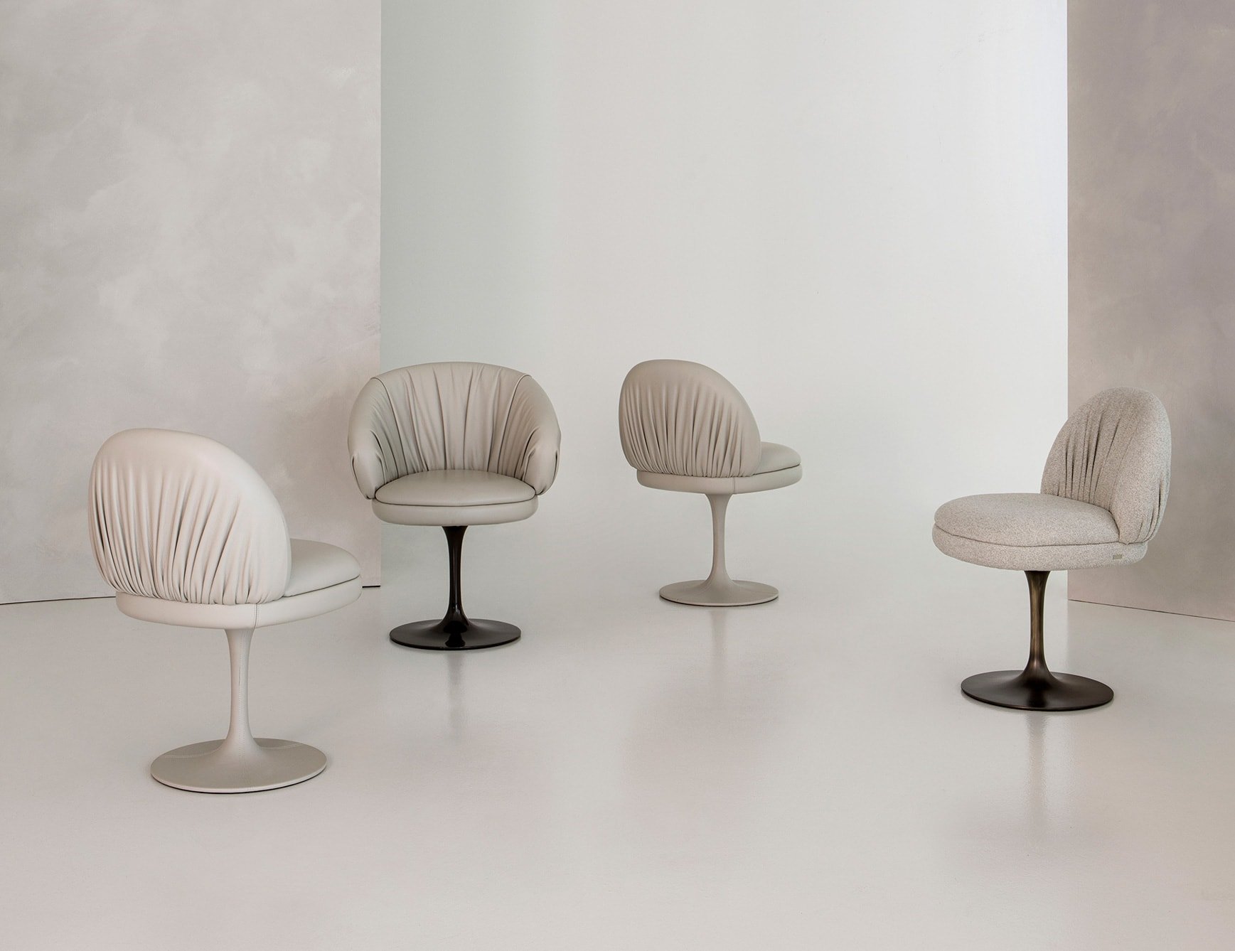 Leather dining chairs with round swivel bases in neutral tones