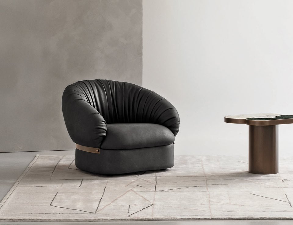 Black leather swivel armchair with rounded backrest on rug