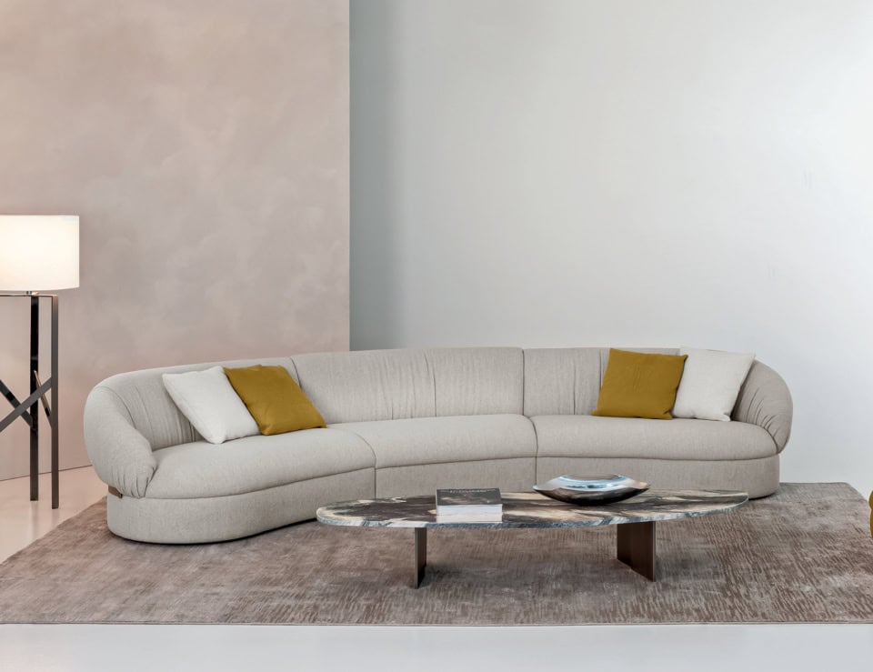 Curved sectional sofa with fabric and upholstered leather finish in living room setting