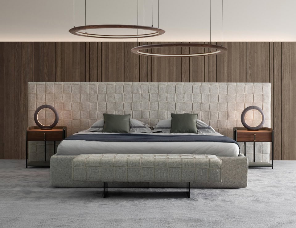 Fabric bench with rectangular seat and metal legs at foot of bed