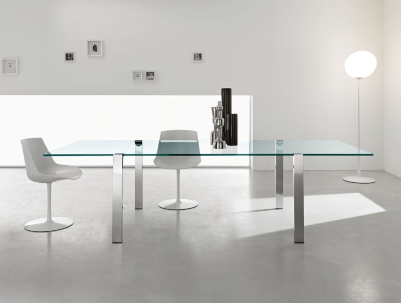 Glass dining table with metal legs and two white chairs
