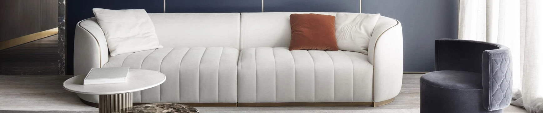 White upholstered sofa with curved arms and gray velvet chair