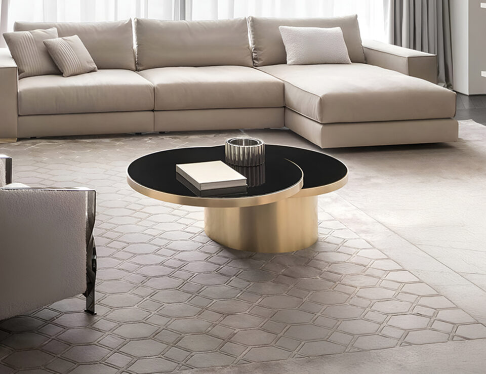 Round metal coffee table with gold base and black top in living room