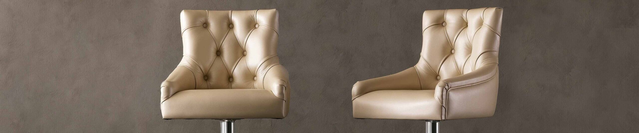 Beige leather upholstered stool with tufted backrest and metal base