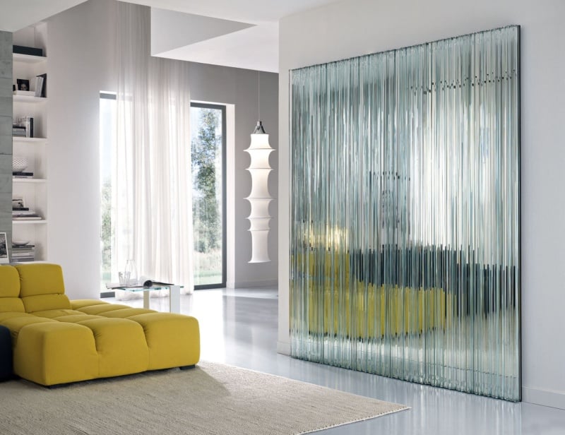 Ribbed glass wall panel with vertical reflective strips in living room